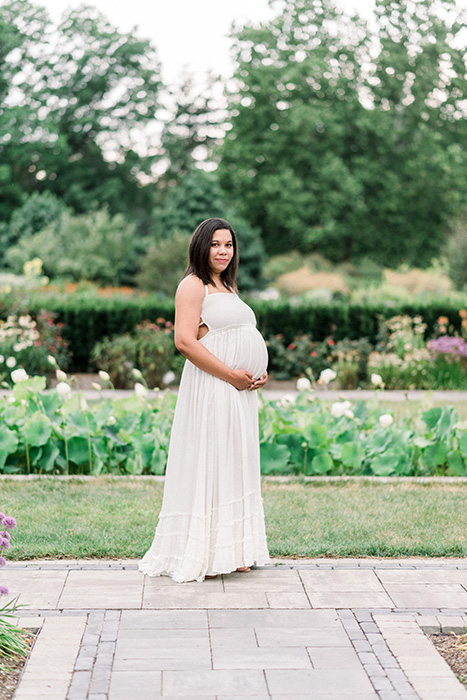 Mom in white dress in botanical garden with Houston maternity photographer