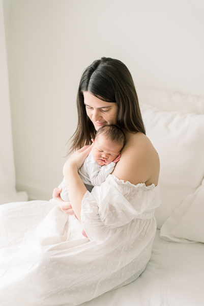 mom holding newborn baby during Houston photographer newborn session