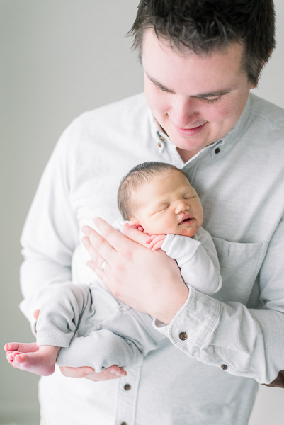 dad holding newborn in Houston photography studio
