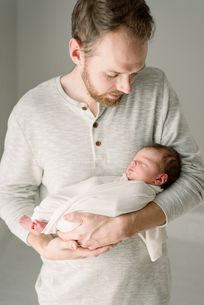 Dad holding newborn during newborn photography session in Houston