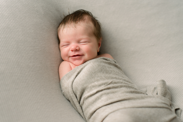 Baby in swaddle smiling