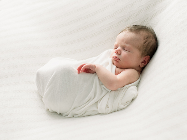 newborn on white blanket, baby led posing