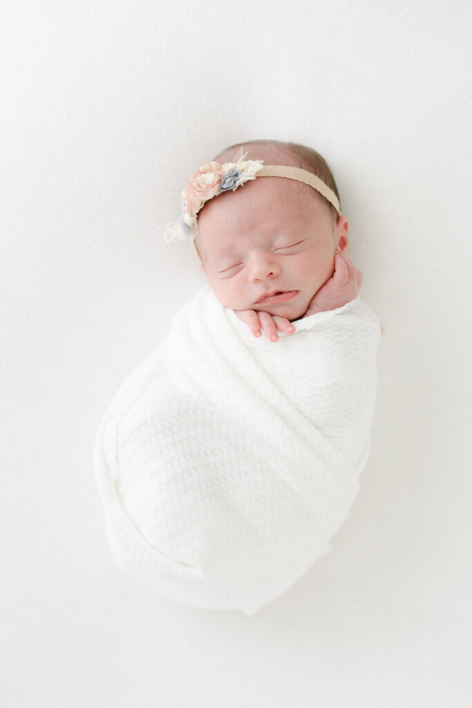 solo newborn portrait in white swaddle and foral headband