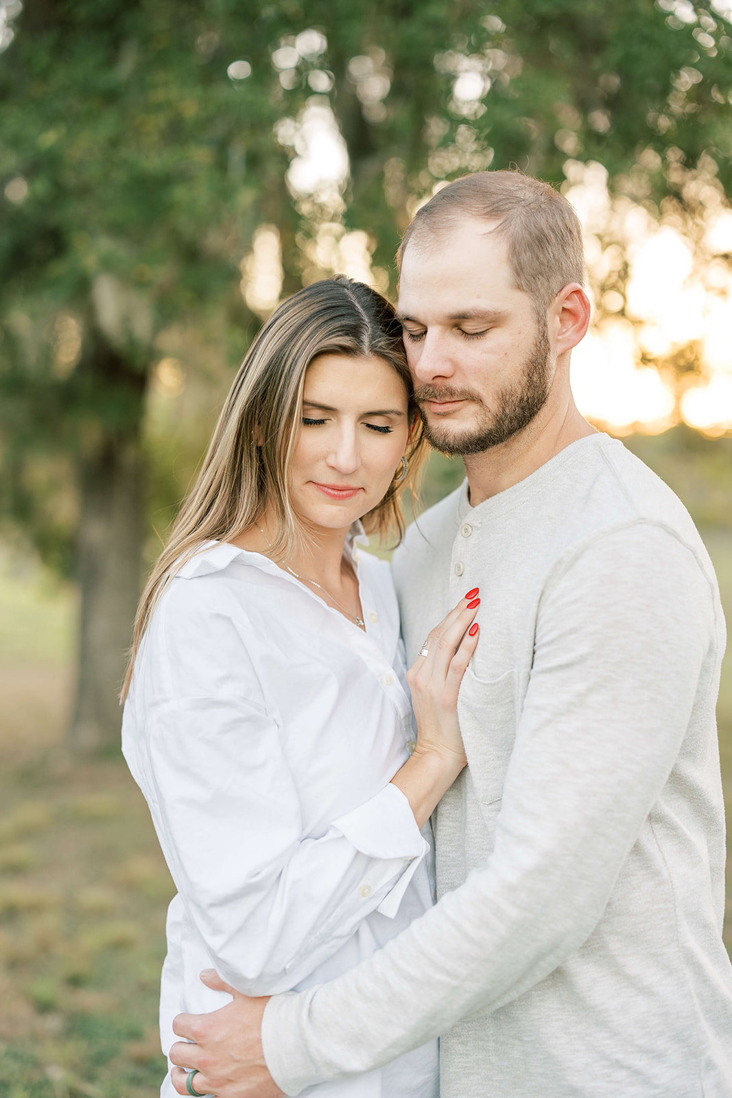 A couple stands in a park at sunset while cuddling before visiting Children's Boutiques in Houston